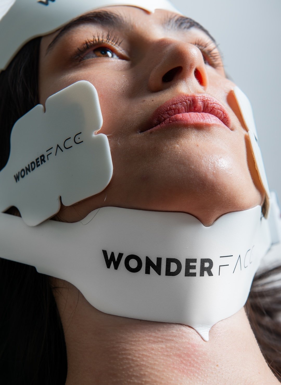 Woman using the Wonder Face facial toning device